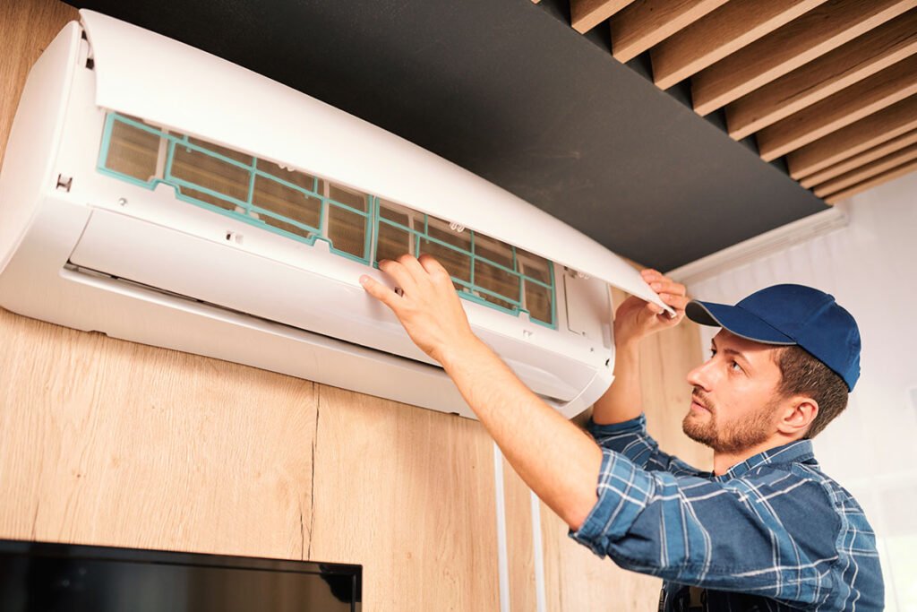 young-technician-opening-lid-of-air-conditioner - Bright Orion AC services